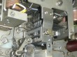 thumbnail photo of a complex mechanism, the central part, held in by bolts, has a row of 8 parallel vertical pins